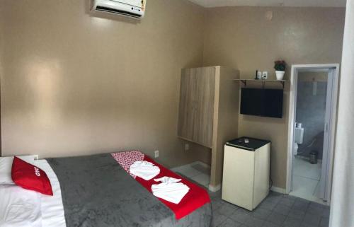 um quarto com uma cama com lençóis vermelhos e brancos em Vila da Pajuçara em Maceió