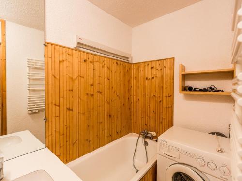 La salle de bains est pourvue d'une baignoire blanche et d'un lave-linge. dans l'établissement Charmant T2 Montchavin La Plagne, 36m², balcon sud, proche pistes et commerces, parking gratuit - FR-1-329-83, à La Plagne Tarentaise