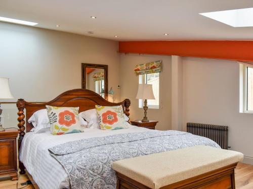 a bedroom with a large bed with a wooden headboard at Sika Cottage - Uk36194 in Fordingbridge