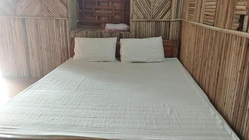 - un lit avec des draps et des oreillers blancs dans l'établissement huy homestay, à Ha Giang