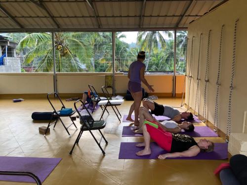 un gruppo di persone che fanno yoga in una stanza di Sandy beach hotel a Trivandrum