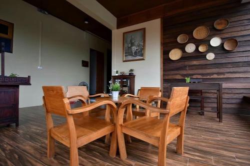 a dining room with a wooden table and chairs at บ้านน่านอน in Uthai Thani