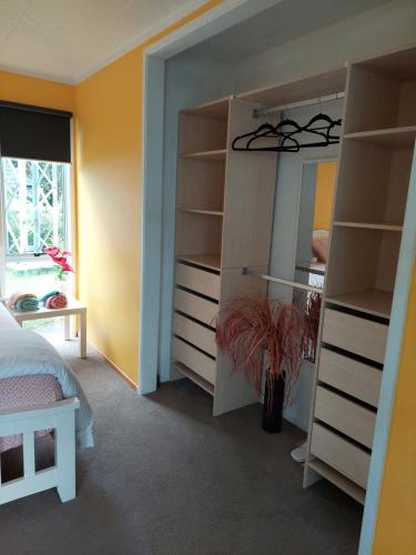a bedroom with a bed and a large mirror at Wendy's Holiday Home in Auckland