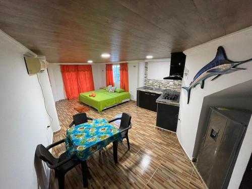 a living room with a table and a kitchen at Posada Ashanty in Providencia