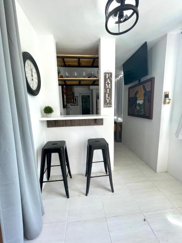 a kitchen with two stools and a clock on a wall at Porta Del Sol CV in Tamarindo