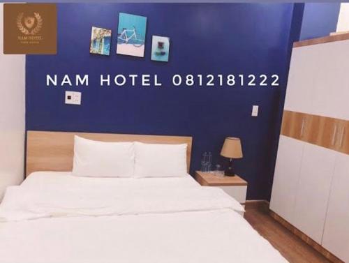 een slaapkamer met een bed met een blauwe muur bij Khach san Nam Hotel in Bản Co