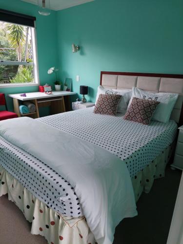 a bedroom with a large bed with a blue wall at Wendy's Holiday Home in Auckland