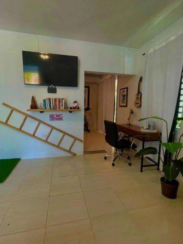 a living room with a desk and a tv on the wall at Porta Del Sol CV in Tamarindo