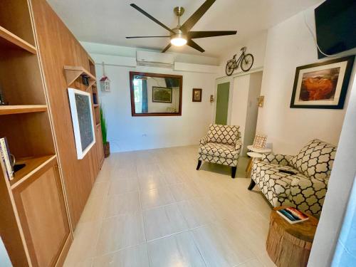 a living room with two chairs and a ceiling fan at Porta Del Sol CV in Tamarindo