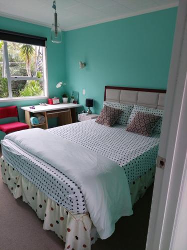 a bedroom with a large bed with a blue wall at Wendy's Holiday Home in Auckland
