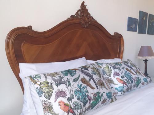 a bed with a wooden head board with a floral bedspread at Emily's in Ballarat