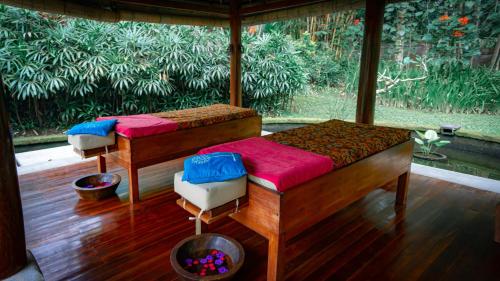 two beds in a room with a large window at The Lotus Residence by Amerta Experience in Tabanan