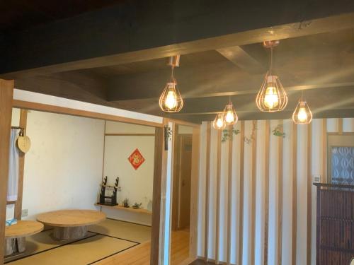 a room with a table and lights on the ceiling at Akitsuki Kominka Ryokan You in Asakura