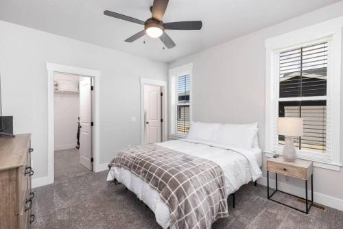ein weißes Schlafzimmer mit einem Bett und einem Deckenventilator in der Unterkunft Charming 3-bedroom in vibrant new neighborhood in Billings