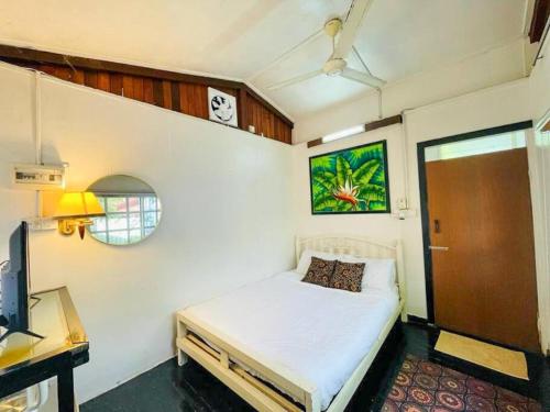una camera da letto con un letto e un orologio a parete di Blissful Cottage a Pantai Cenang