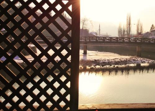 a view of a river through a fence at Pansion River in Sarajevo