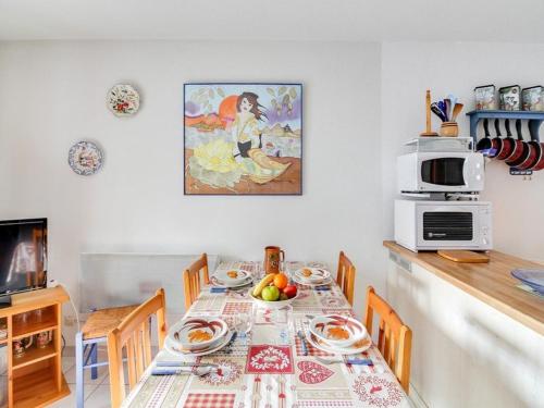 - une salle à manger avec une table, des chaises et un four micro-ondes dans l'établissement T3 Duplex 43m², 2 chambres, balcon, animaux admis, calme, proches commodités, 3 stations ski - FR-1-402-29, à Esquièze - Sère