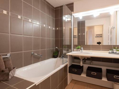 La salle de bains est pourvue d'une baignoire, d'un lavabo et d'un miroir. dans l'établissement Appartement Vielle-Aure, 2 pièces, 4 personnes - FR-1-296-290, à Vielle-Aure