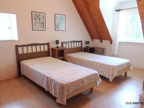 twee bedden in een kamer met twee ramen bij Maison Fouesnant, 5 pièces, 8 personnes - FR-1-481-47 in Fouesnant
