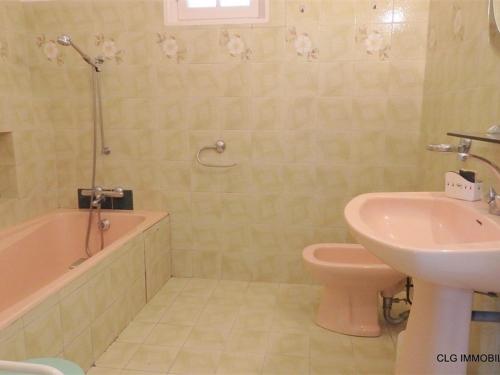 een badkamer met een wastafel, een toilet en een bad bij Maison Fouesnant, 5 pièces, 8 personnes - FR-1-481-47 in Fouesnant