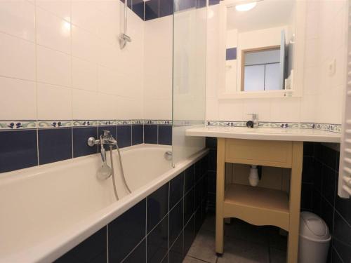 ein Badezimmer mit einer Badewanne und einem Waschbecken in der Unterkunft Appartement Fouesnant, 2 pièces, 4 personnes - FR-1-481-83 in Fouesnant