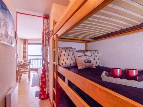 - une chambre avec un lit doté d'un cadre en bois dans l'établissement Charmant studio pour 4 proche des pistes à Saint-Lary-Soulan - FR-1-296-363, à Saint-Lary-Soulan