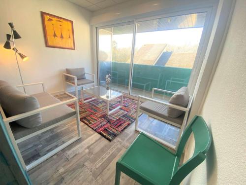a living room with a chair and a table at Duplex à Combrit: plage à pied, piscine chauffée et tennis - FR-1-481-101 in Combrit