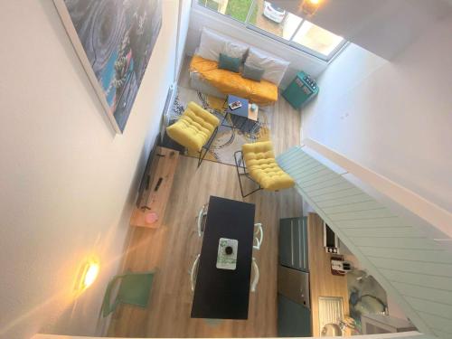 an overhead view of a living room with yellow chairs at Duplex à Combrit: plage à pied, piscine chauffée et tennis - FR-1-481-101 in Combrit