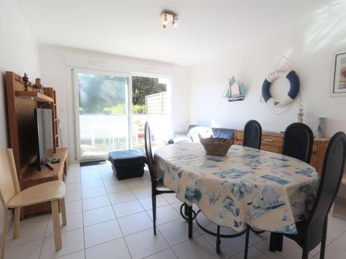 une salle à manger avec une table, des chaises et une télévision dans l'établissement Triplex cosy à Bénodet : Terrasse, Jardin, Plage et Thalasso à 200m ! - FR-1-481-104, à Bénodet