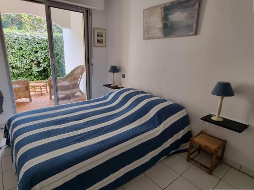 - une chambre avec un lit rayé bleu et blanc dans l'établissement Arcachon, Ville de Printemps - Appartement T2 avec Jardin à 250m des Plages - FR-1-433-91, à Arcachon