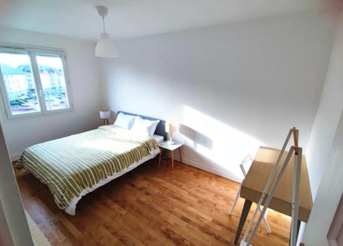 ein kleines Schlafzimmer mit einem Bett und einem Fenster in der Unterkunft Appartement 76m2 lumineux centre ville garage privé 3ieme étage sans ascenseur in Fougères