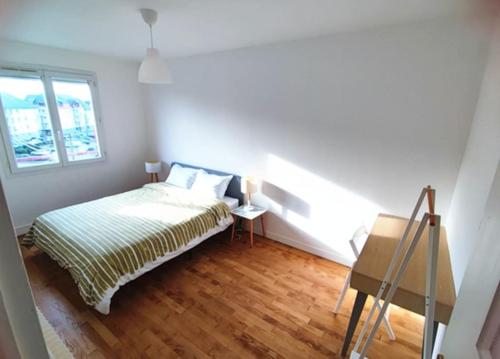 une petite chambre avec un lit et une fenêtre dans l'établissement Appartement 76m2 lumineux centre ville garage privé 3ieme étage sans ascenseur, à Fougères