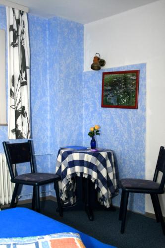 a blue room with a table and two chairs at Frauenpension Arleta - Women only in Goslar
