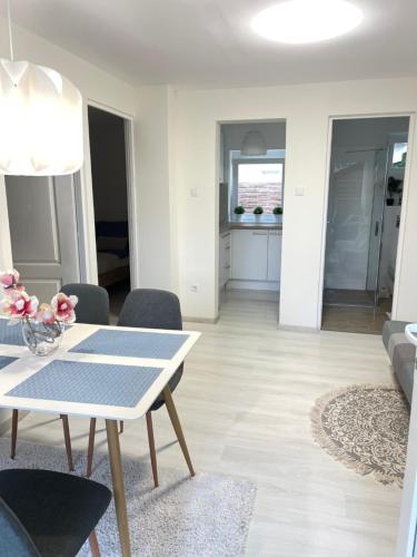 a white living room with a table and chairs at Relax Nyaraló Dombori in Fadd-Dombori