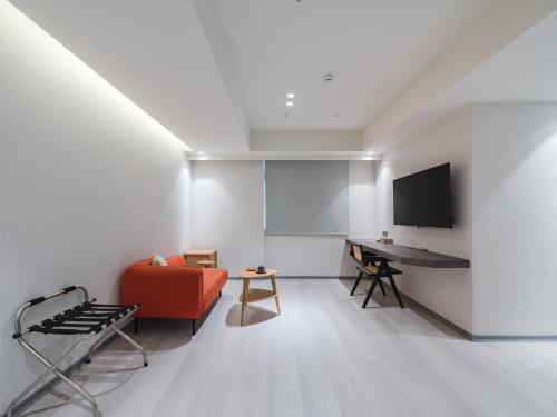 a living room with a red couch and a desk at Dahu Park Hotel in Taipei
