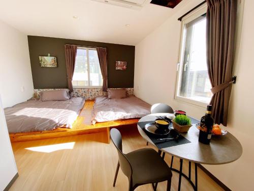 1 dormitorio con 1 cama y 1 mesa con sillas en Q FOX GMG HOTEL, en Niseko