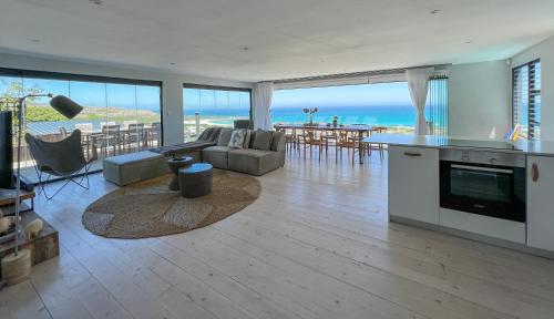 a kitchen and living room with a view of the ocean at Namaste Cape Point in Cape Town