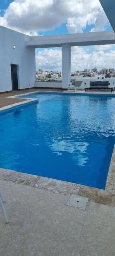 una gran piscina azul en la parte superior de un edificio en Brickell Hotel apto g 08 Santo Domingo Bella Vista, en Santo Domingo
