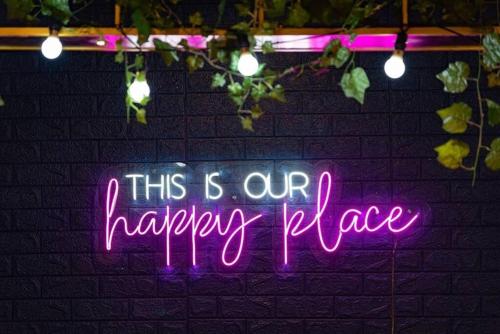 a neon sign that says this is our happy place at Luxurious Villa with Private Swimming Pool, Kids Pool, Games, Private Parking in Calangute