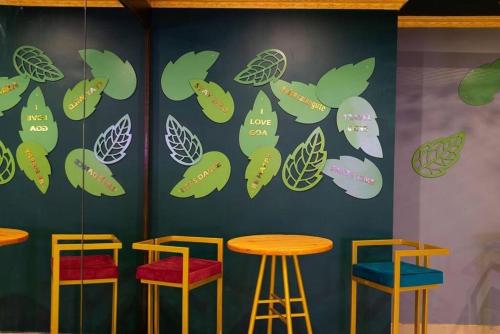 a wall with green leaves and stools in a restaurant at Luxurious Villa with Private Swimming Pool, Kids Pool, Games, Private Parking in Calangute