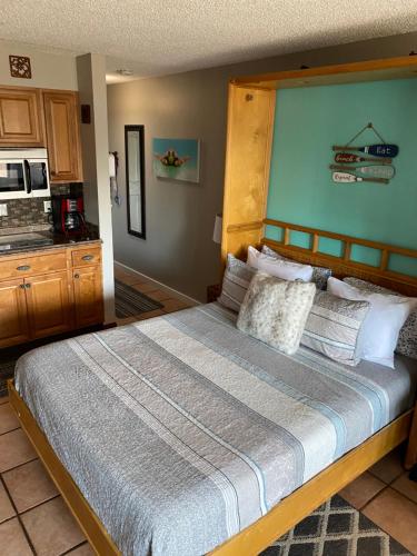 a bedroom with a large bed and a kitchen at Da Kona West 305 in Kailua-Kona