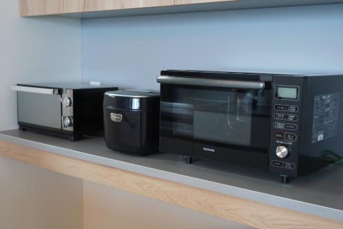 a microwave and a toaster oven on a counter at Beach SPA TSUDA 0 Cero棟 in Sanuki