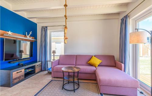 Una sala de estar con un sofá morado y un televisor. en Slow Down, en Büsum