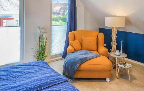 ein Schlafzimmer mit einem orangenen Stuhl und einem Bett in der Unterkunft Slow Down in Büsum