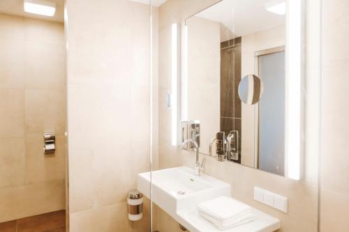 a white bathroom with a sink and a mirror at Kickmaier's in Kirchbach in Steiermark