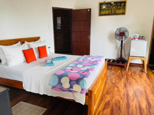 a bedroom with a bed and a fan at Poomaz Peace Palace in Ella
