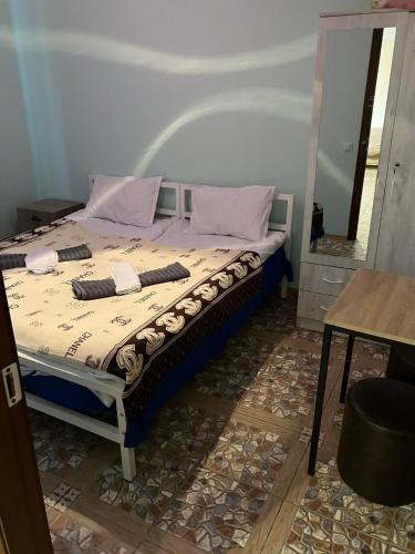 a bed in a room with a table and a mirror at Lali in Tbilisi City
