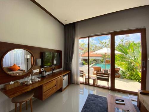 a living room with a tv and a mirror at Nau Nusa Villa in Nusa Penida