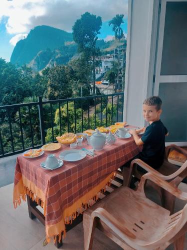 a young boy sitting at a table with food on it at Poomaz Peace Palace in Ella