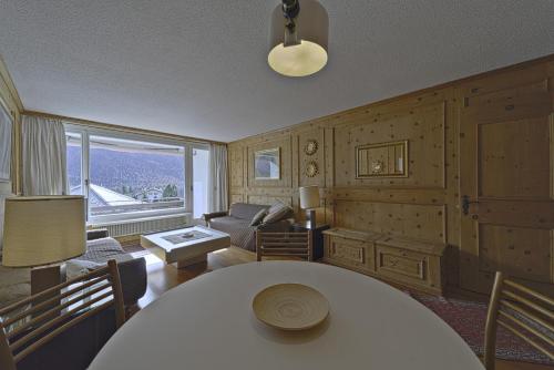 a living room with a table and a couch at Allod Brattas - Sankt Moritz in St. Moritz